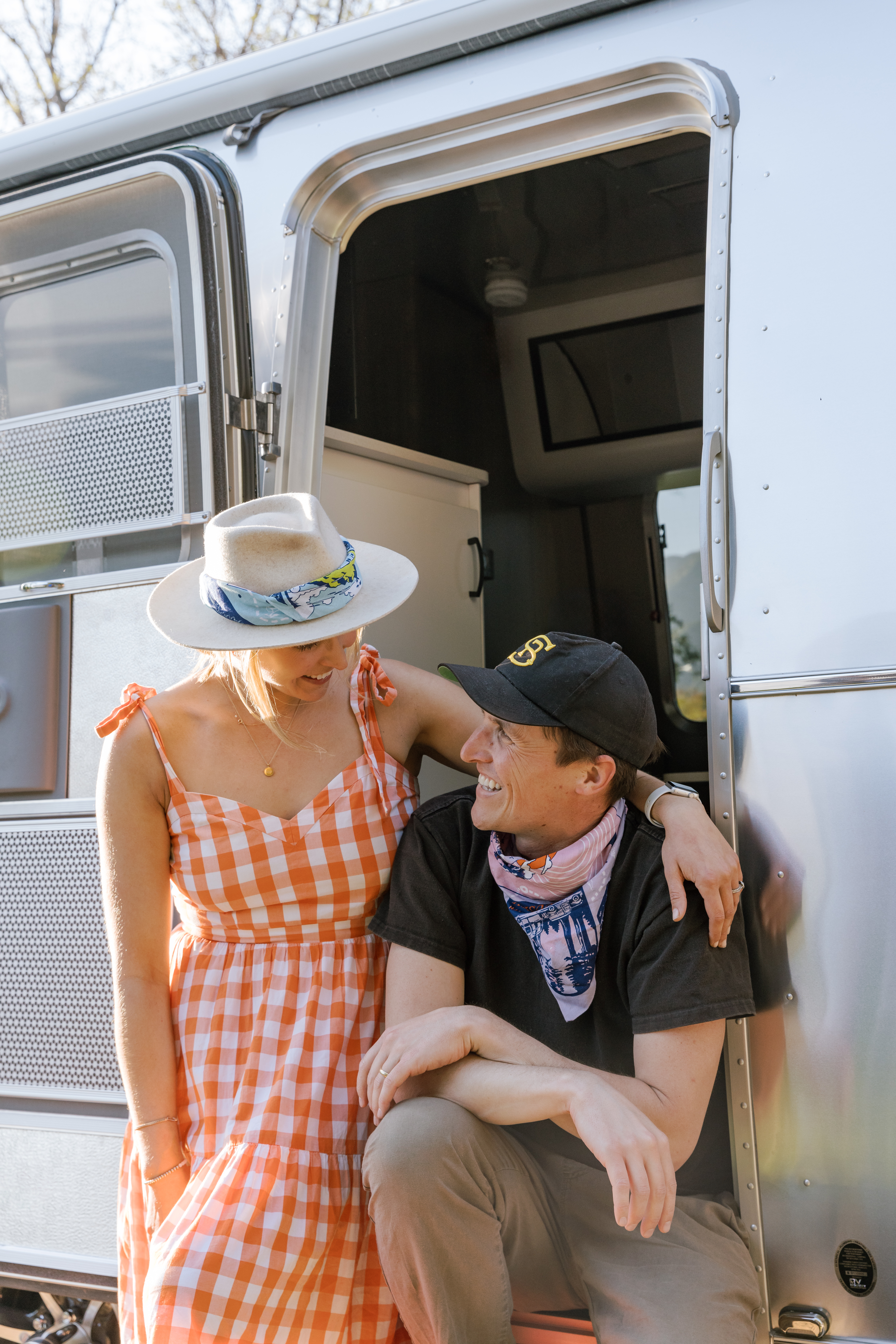 Models wearing artist-designed Bandits × Airstream bandanas beside an Airstream trailer
